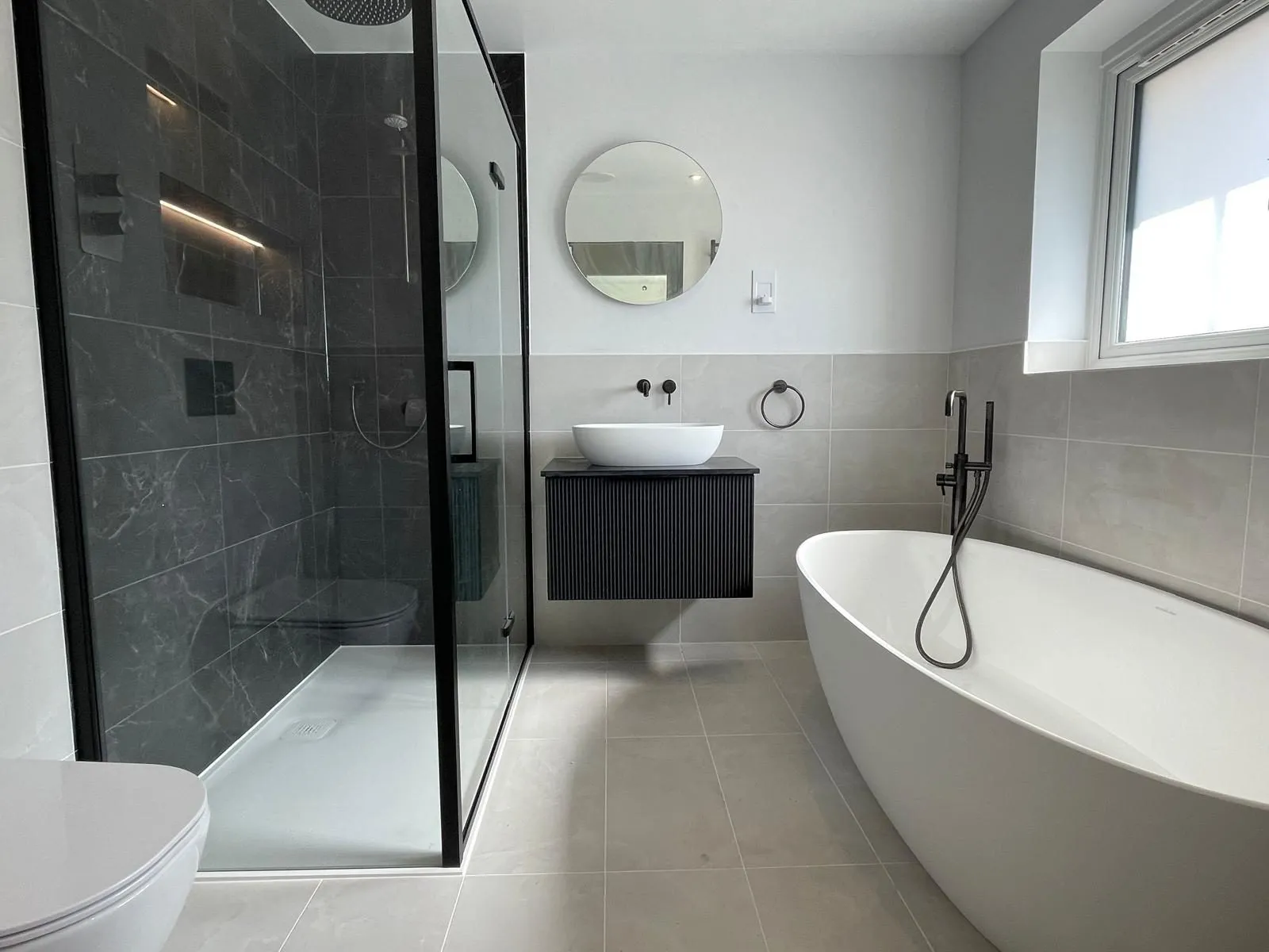 Bathroom with freestanding bath and walk-in shower completed by Trade Square in Egham