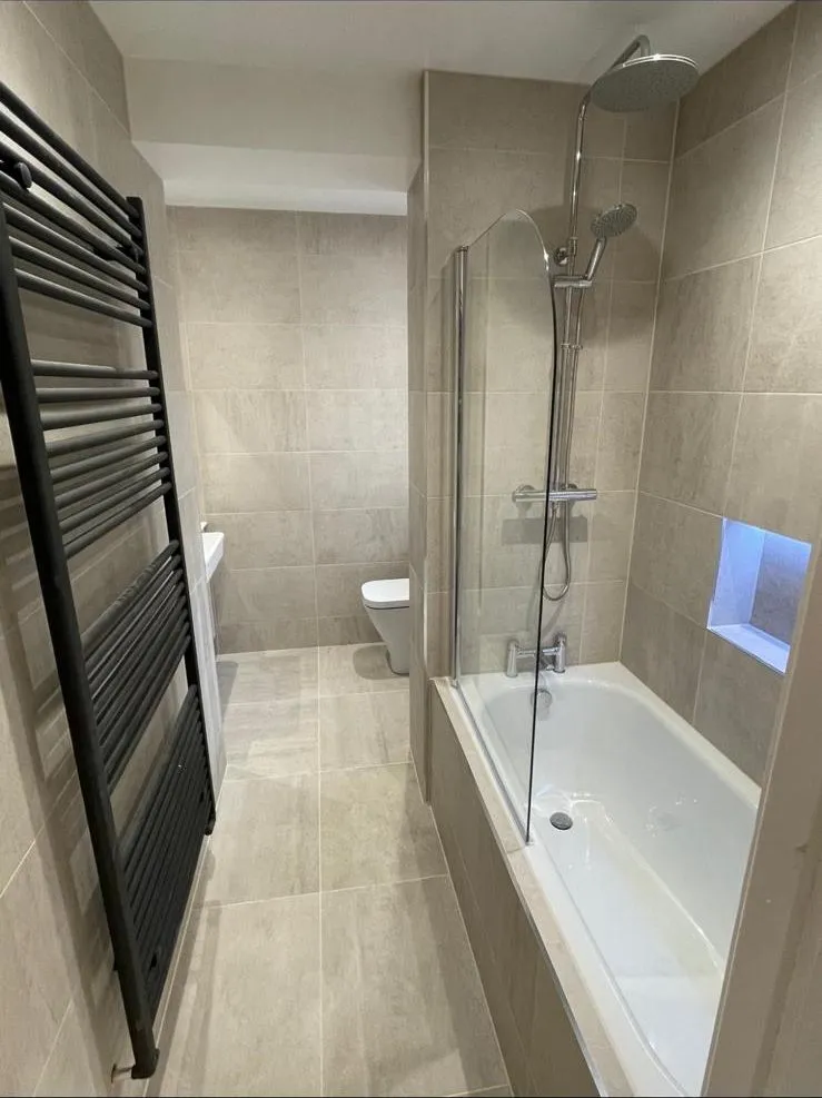 Shower bath and towel radiator in a renovated Egham bathroom