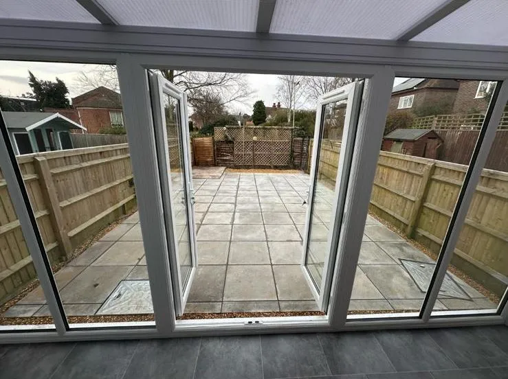 Conservatory extension opening onto a paved patio in Egham