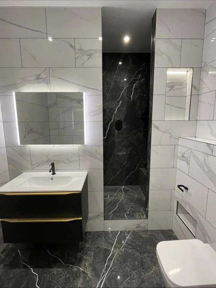 Marble-effect bathroom with walk-in shower and illuminated mirror in Egham