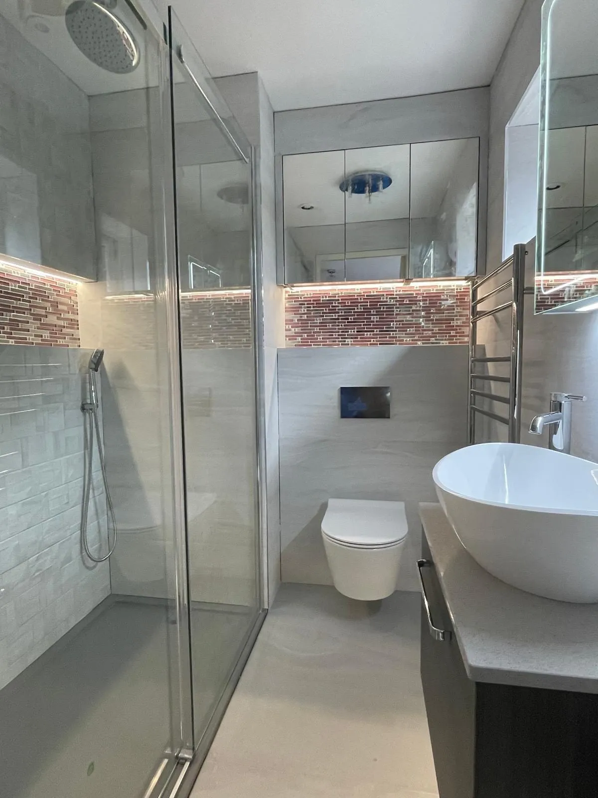 Shower room with vanity basin and tiled feature wall in Egham